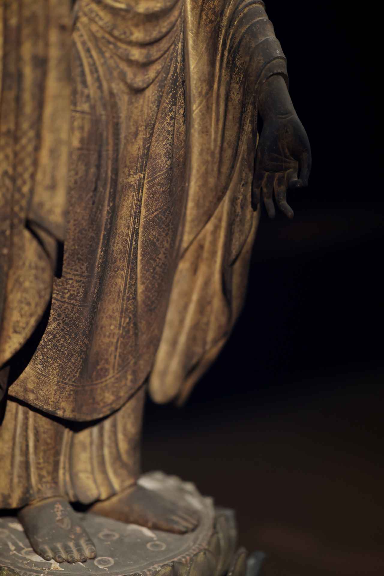 画像: 木造金彩阿弥陀如来立像 鎌倉時代・13世紀 藤田美術館(部分) 衣の全体に細かく施された截金の紋様。左足を踏み出している