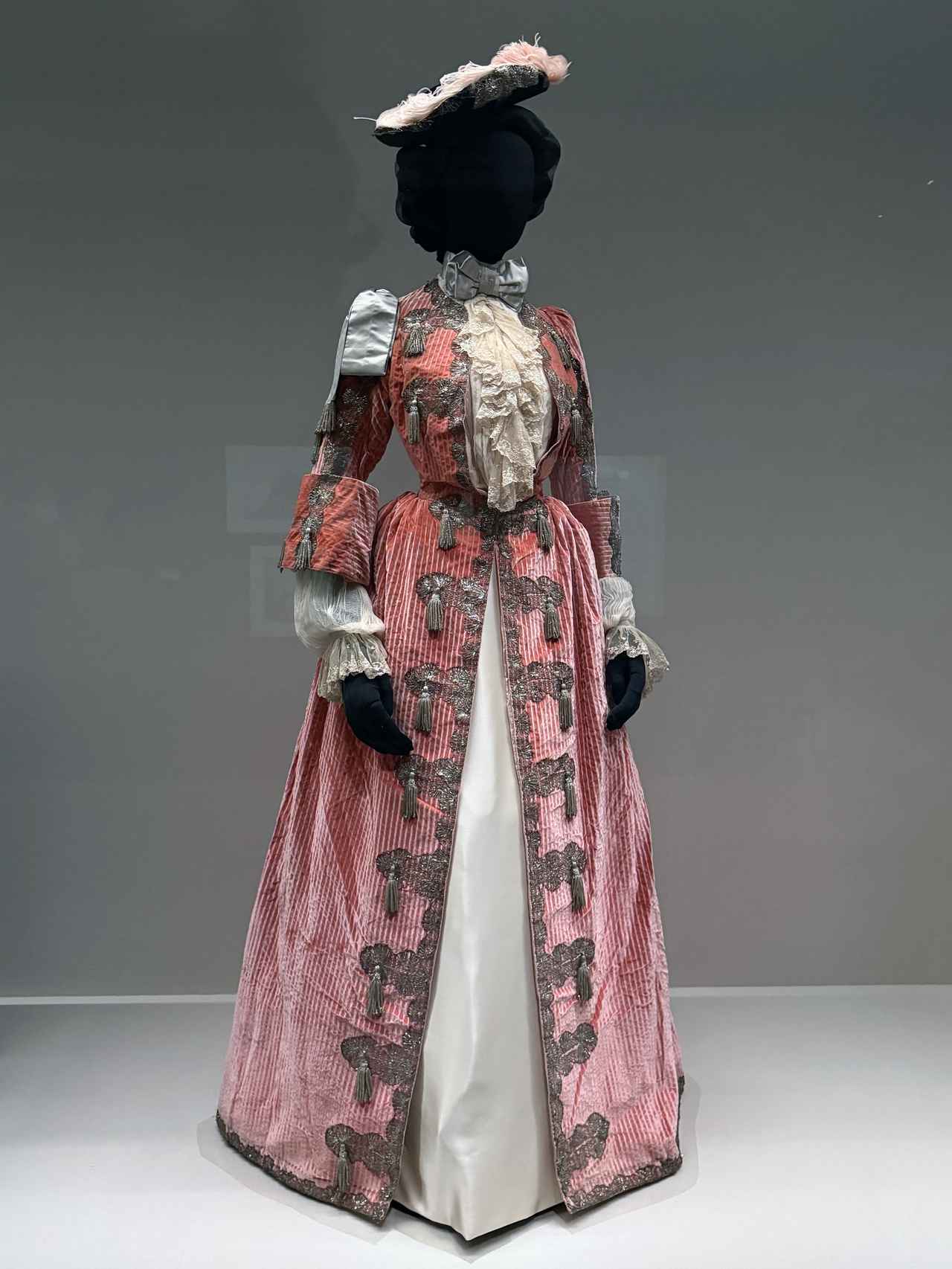 画像: 展示風景：《トリコーン帽》　オーギュスト・プティ　1897年、メゾン・ウォルト～　《仮装ドレス》　(1897年)　ともにヴィクトリア＆アルバート博物館蔵 photo©︎moichisaito