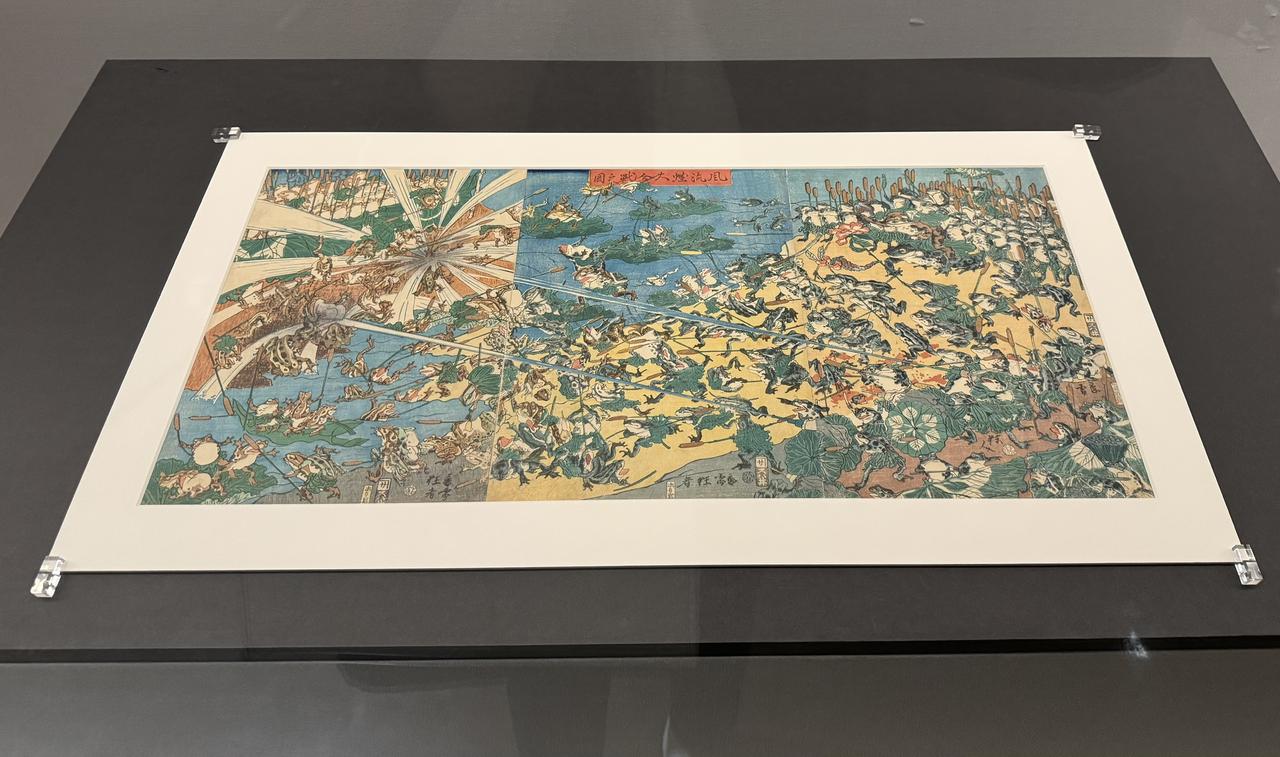 画像: 河鍋暁斎《風流蛙大合戦之図》 元治元年7月（1864年7月）　大判錦絵三枚続 イスラエル・ゴールドマン・コレクション 　展示期間：7月11日（土）～8月16日（日）【日本初出品】 神戸市立博物館　特別展「ゴールドマン コレクション　河鍋暁斎の世界」内覧会にて撮影　photo by © cinefil