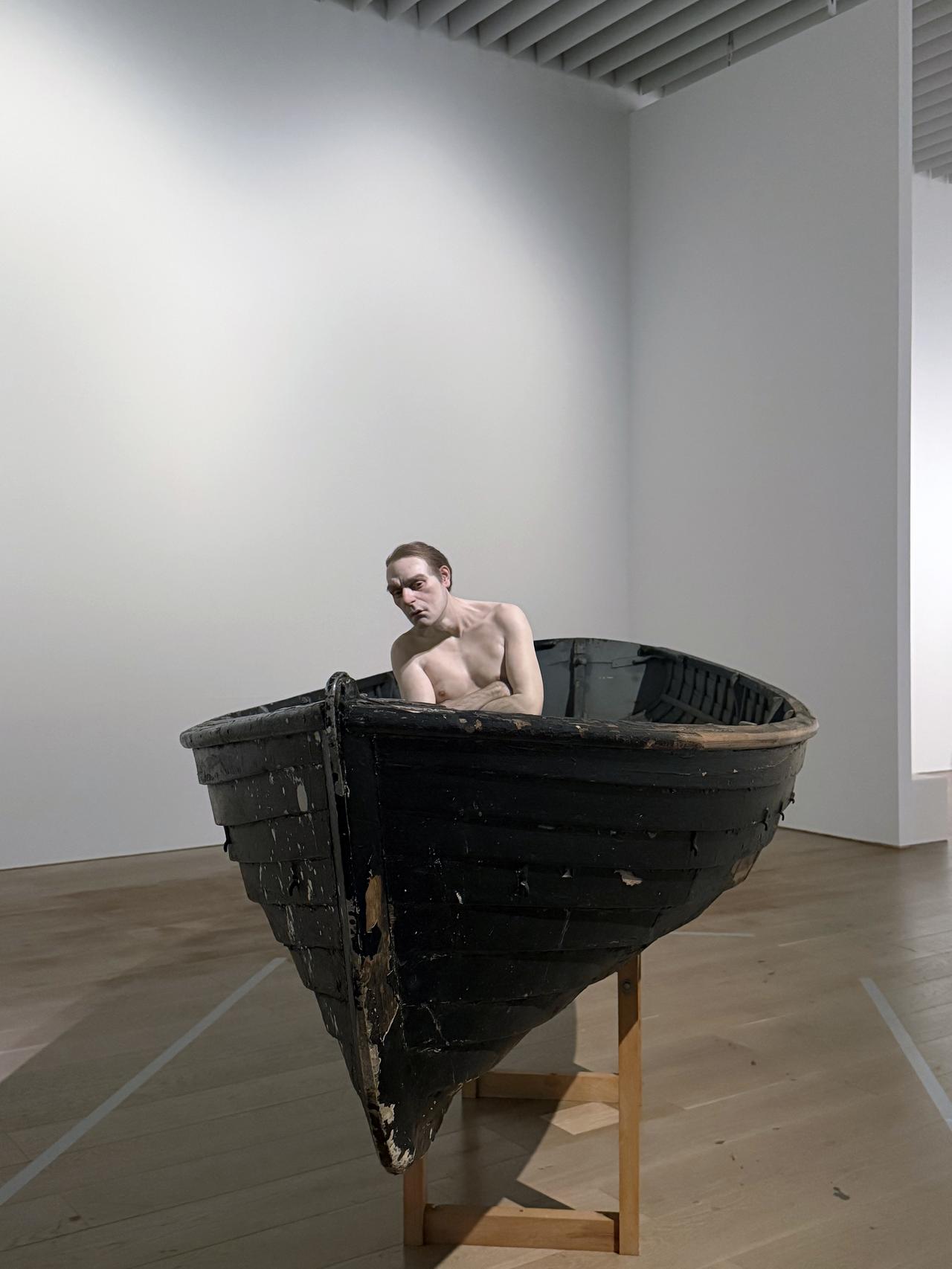 画像: ロン・ミュエク　《舟の中の男》　2002 年　ミクストメディア　159 × 138 × 425.5 cm　個人蔵 展示風景：「ロン・ミュエク」森美術館（東京）2026 年 photo©︎moichisaito