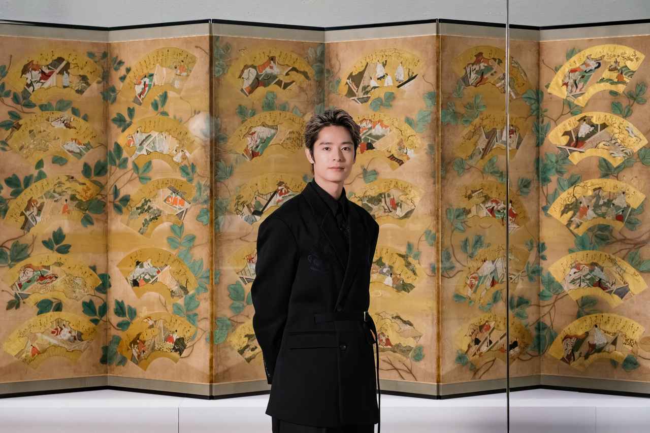 画像: 《源氏物語図扇面貼交屛風》(広島・浄土寺蔵)の前にて、音声ガイドナビゲーターを務める俳優・塩野瑛久さん 特別展「源氏物語 王朝のかがやき」会場写真(京都)