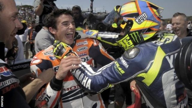 画像: レースで負けたから、腕力でマルケスを倒しにかかるロッシ。暴力反対!と笑顔で訴えるマルケス(*一部脚色あり) news.bbcimg.co.uk