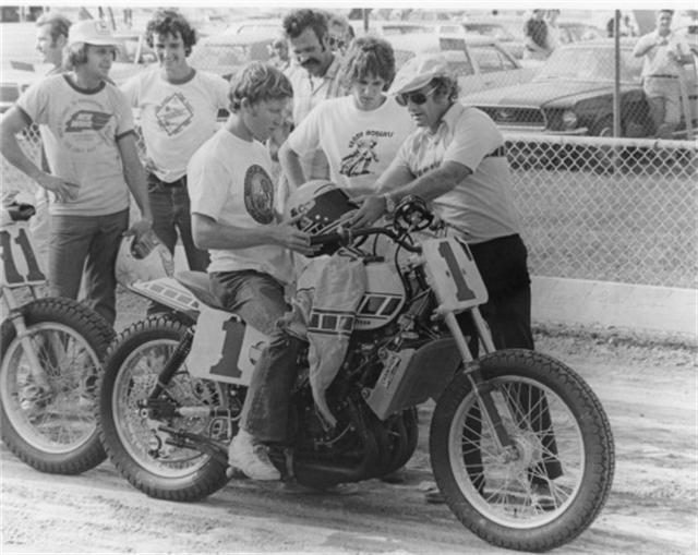 画像: TZ750ダートトラッカーに跨るケニー。ハンチング&サングラスの人物は、ケル・キャラザースです。 images.cyclenews.com