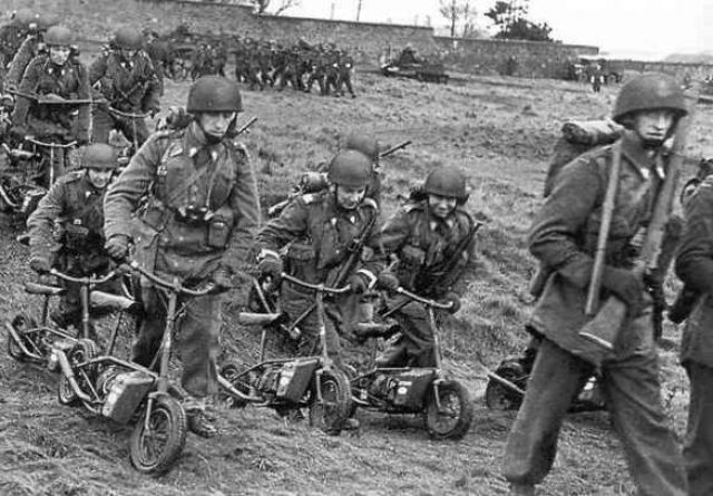 画像: ウェルバイクと英国軍兵士たち。戦場という緊迫した場面ですが、ウェルバイクのユーモラスな姿が浮いて見えてしまいます。 s1jzu5hcgojbfje2ba52v9a8.wpengine.netdna-cdn.com