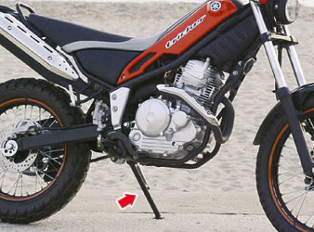画像: 駐輪の際にバイクを支え、車体を傾けて停めるタイプのサイドスタンド www.weblio.jp