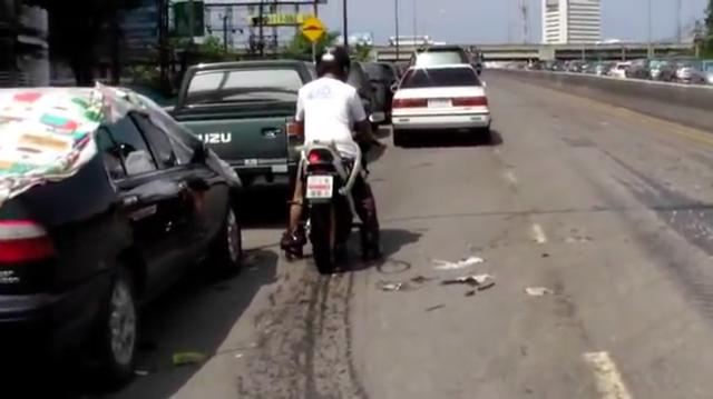 画像: ひと仕事?終えて、水のない高い位置の道路に来たライダーとモーターサイクル。ん?・・・何やらホースのようなものが見えますね? www.youtube.com