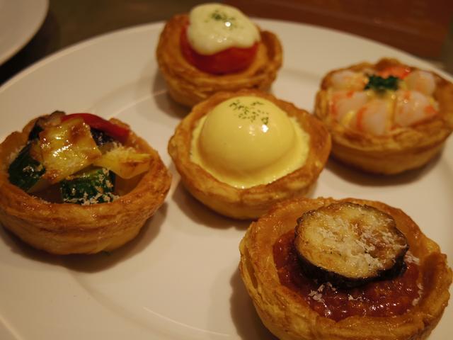 画像: 右手前:ラザニア 左端:ラタトゥイユ 各480円(税抜) 中央:エッグベネディクト 奥:丸ごとトマト2種のチーズソース 右端奥:エビリゾットビスクソース 各580円(税抜)