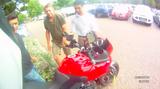 画像: 周囲の人たちが、転倒したモーターサイクルを起こすのを手伝ってくれます。う〜ん、人間の優しさがよくわかるシーンですね? ところで、前輪右に見える「黄色い」何かにみなさんは気づきましたか? www.youtube.com