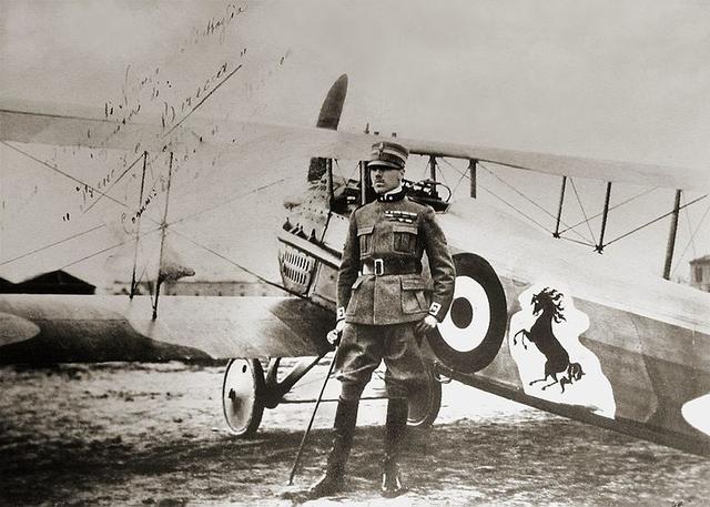 画像: 第一次世界大戦でイタリアのエースパイロットとして活躍したフランチェスコ・バラッカ。愛機スパッドの機体には、「跳ね馬」が描かれています。なおバラッカは、この写真が撮影された1918年に亡くなっています。 en.wikipedia.org