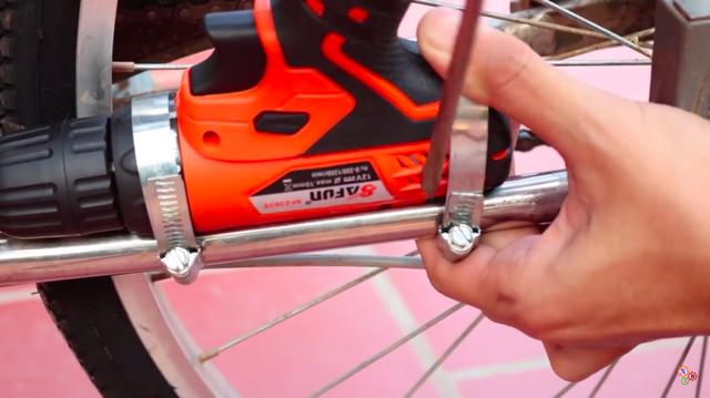 画像: ホースバンドや結束バンドでドリルドライバーを自転車のフレームに固定します・・・。 www.youtube.com