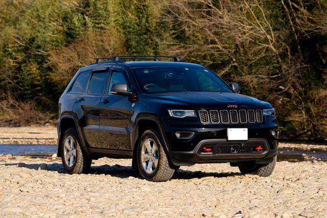 画像: エンブレムの一部や牽引フックにアクセントのレッドが効いている、限定車のGrand Cherokee Trailhawk。