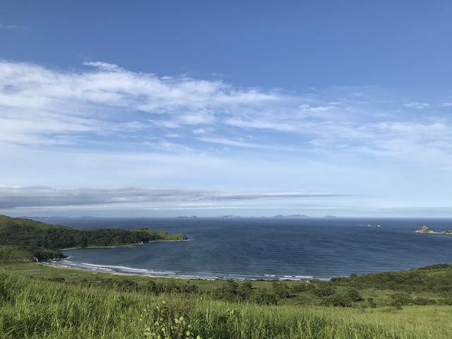 画像: 山の中腹から・・・往路の約半分の地点からの、目的地の東岸のビーチの眺め。その美しさには目を見張りましたが、「今までの行程と、ここからビーチまでの距離を、帰りも歩かないといけないんだな・・・」という思いもちょっとよぎってしまいました(苦笑)。