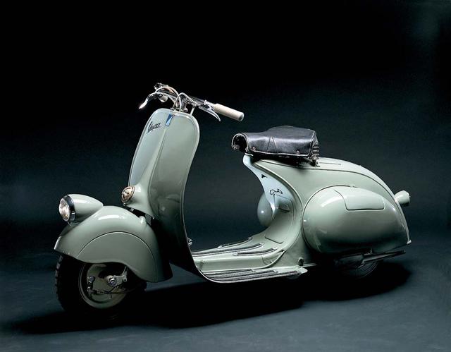 画像: 1946年のベスパ(98cc)。女性がスカート姿でも気軽に乗れるステップスルーのデザインを持ち、女性に移動の自由=社会進出へのきっかけを与えた乗り物としても、歴史にその名を残しています。 kaneban.txt-nifty.com