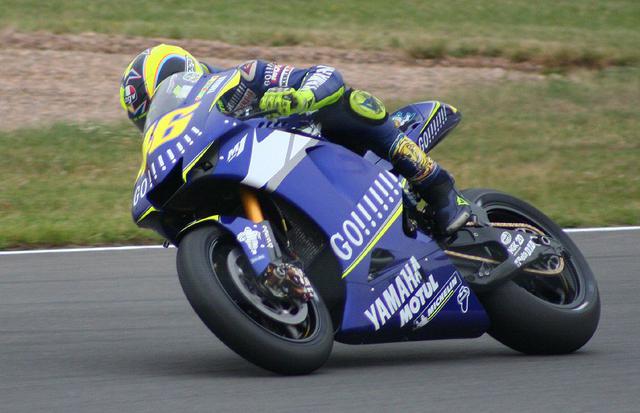 画像: 2005年、ヤマハYZR-M1に乗るバレンティーノ・ロッシ。広告規制でタバコブランドのロゴを表記できないため、このように「GO!!!!!!!!」とブランドを連想させるような文字を入れてみたり、バーコードを入れてみたりと、タバコ会社はあれこれ策を練ったものでした。 es.wikipedia.org