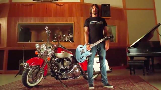 画像: デイヴの愛車、ロードキングとともに。フー・ファイターではフロントマンのデイヴはボーカルとギターがメインですが、動画の中では彼の「ドラム」を堪能することができます。 www.youtube.com