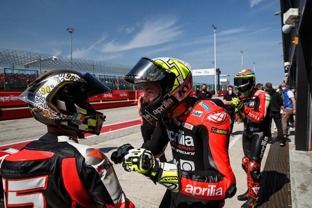 画像: ピット前でトークを楽しむロリス・カピロッシ(左)とアレイシ・エスパルガロ。 www.aprilia.com
