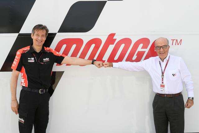 画像: 距離を保ち、グータッチをするアプリリア・レーシングCEOのマッシモ・リヴォラ(左)と、ドルナ・スポーツCEOのカルメロ・エスペレータ。