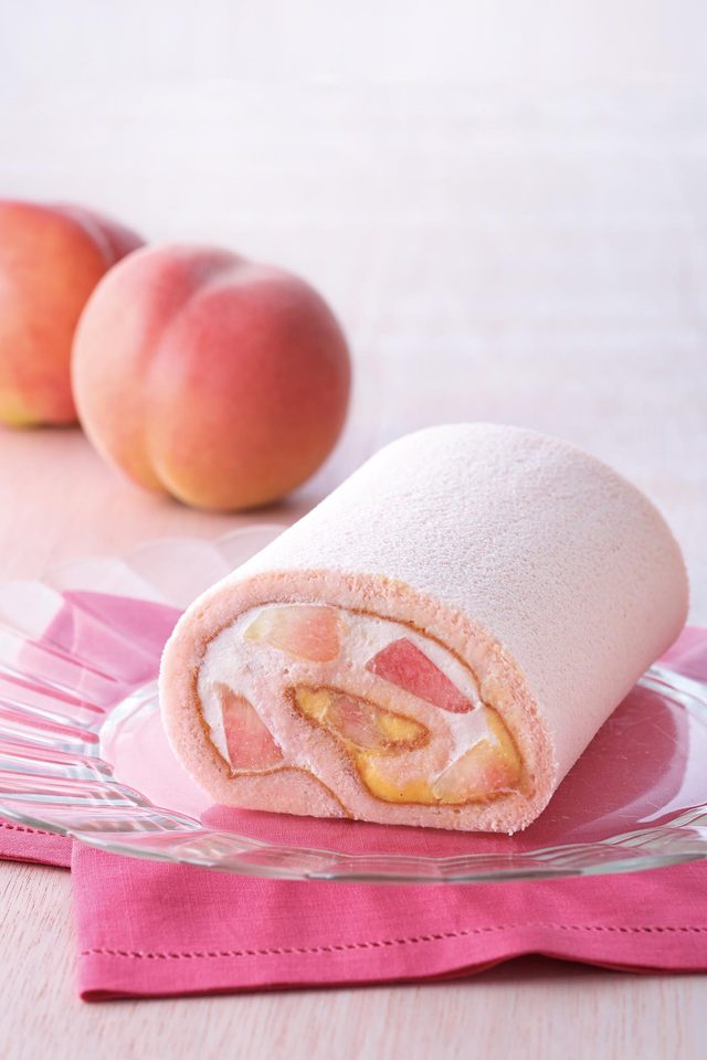 画像: ■商品名:季節のトライフルロール 白桃 ■価格:カット 584 円、約14cm 2,268 円(税込) ■販売期間:7 月1 日(水)~ 8 月31 日(月) ■商品説明: 甘く香るみずみずしい白桃を、ラズベリー果汁を加えたほんのりピンクのスフレ生地で巻いた、季節限定のロールケーキ。キハチトライフルロール®で使用しているディプロマットクリームと、白桃とパッションフルーツのピュレを加えた生クリームでさわやかな味わいに仕上げました。