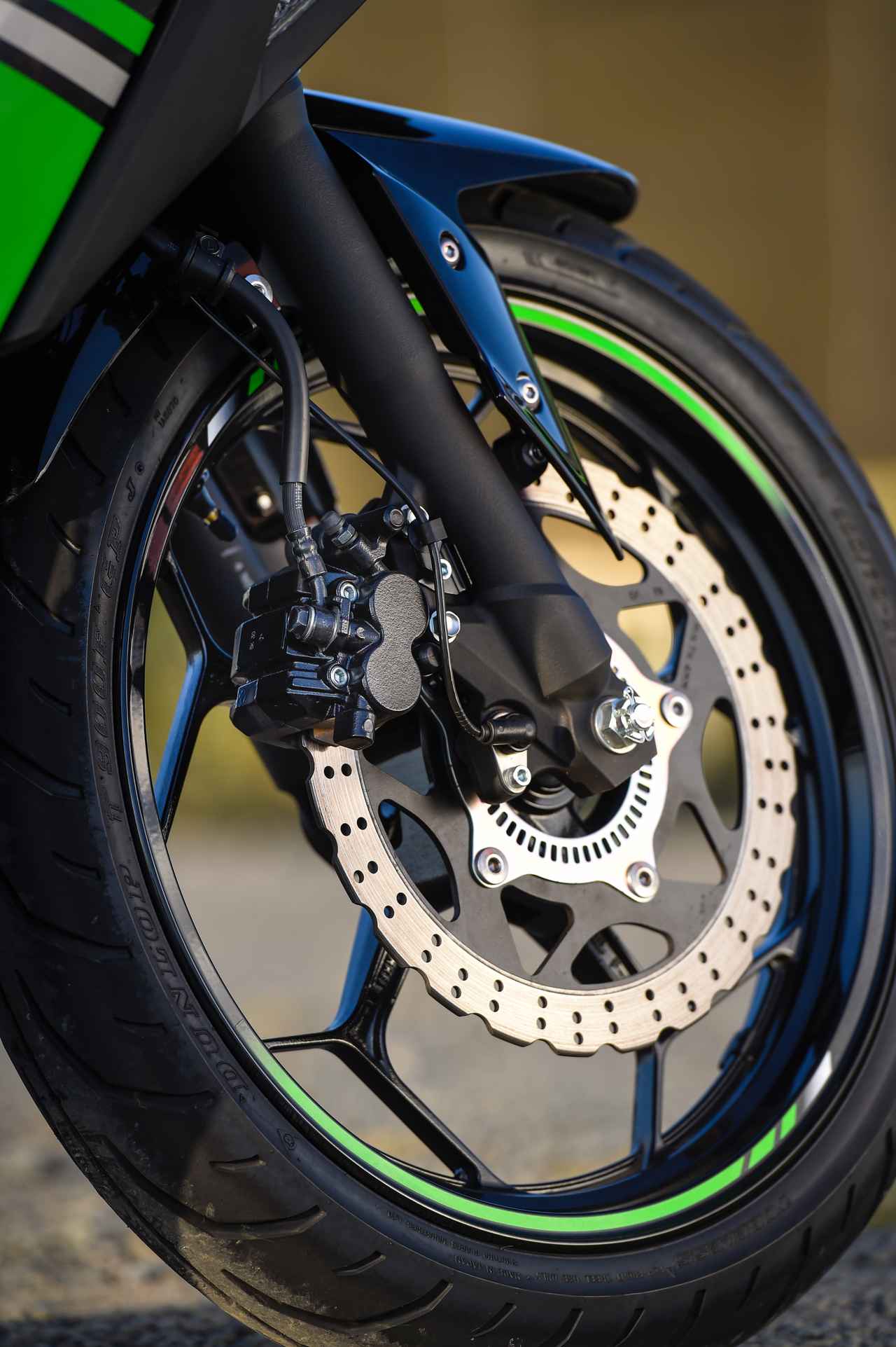 画像: 250cc とは思えない、こだわりのディテール 1. 軽快な走りを予感させる 10 本スポークのホイールに、ライムグリーンのリムラインがアクセントとして効いている。ブレーキはコントロール性重視。フロントサスが柔らかいので、街乗りやツーリングも快適だ。