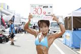 画像: 女子ボディビルダーの山田純子さん。 今日はHonda向陽会ドリームレーシングチームの応援に駆けつけたとのこと。
