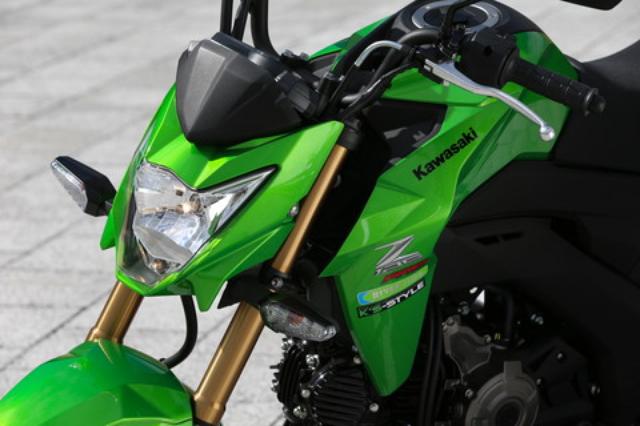 画像: 兄貴分のZ250SLにも似たデザインの、シャープな形状のV字型ヘッドライトを採用。タンク両サイドに配したシュラウドと合わせ、迫力のフロントマスクを演出している。