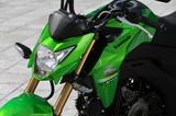 画像: 兄貴分のZ250SLにも似たデザインの、シャープな形状のV字型ヘッドライトを採用。タンク両サイドに配したシュラウドと合わせ、迫力のフロントマスクを演出している。