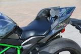画像: ライダーが加速時に後ろにズレないよう、左右にヒップサポートパッドを配置。テールカウルのサイドパネルをずらすことで、最大15mm幅で前後調整も可能となっている。