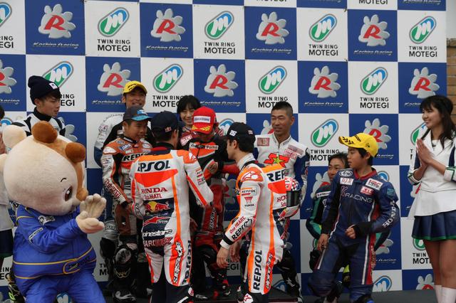 画像: レースの表彰式にも参加したマルケス選手とペドロサ選手。表彰台に立ったキッズライダーに、サインのサービスも。