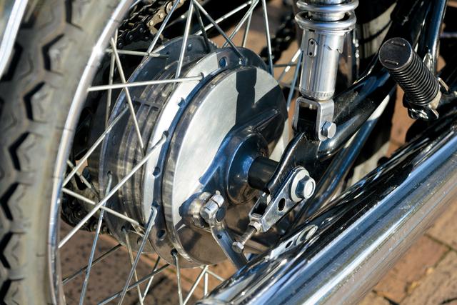 画像: 有効径180㎜のドラム式ブレーキをリア側に採用。消音器は3つのセパレーターを持つ厚みのある構造であり、排気音の静かさをセールスポイントにしていた。