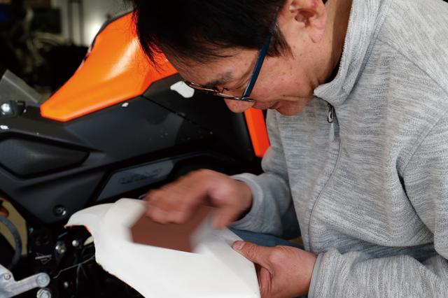 画像: 塗装面の下地作りにはスポンジサンダーが便利。磨きクズを流すように水を掛けながら作業すると効率的だ。