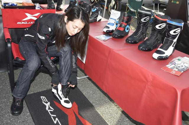 画像: 山城ブースではEXUSTAR(エグザスター)のブーツを多数展示! ツーリングブーツからレーシングブーツまで幅広くラインアップしている。ブーツ自体は日本人の足型に合わせた作りとなっており、試着サービスも人気となっていました。というわけで、朱香試し履きの様子。 www.kkyamasiro.co.jp
