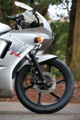 画像: フロントブレーキキャリパーは片押し2ポット。17インチフロントタイヤは、NS50Fより太い90/80‐17サイズを採用。姿勢が少し前下がりでフロント荷重がかかりやすくなっている。