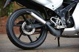 画像: リアがディスクブレーキなのもNS50Fとは違う部分。6本スポークのデザインはホンダスポーツバイク共通のデザイン。サイレンサーが黒じゃなくアルミ風なのは後期型の特徴である。