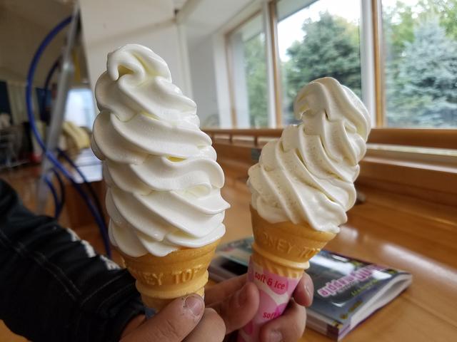 画像: ちょっと寒いと言いつつ『乳酪館』でカマンベールチーズソフト(左)とバニラソフト(右)。ソフトクリームは道の駅『メルヘンの丘 めまんべつ』でも買えます。