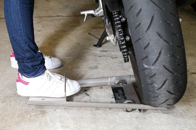 画像: タイヤの下にバイクリフターを滑り込ませ、あとは踏み込めばリアタイヤが浮いた状態になる。その状態でバイクを押せば、簡単にタイヤ位置をスライドさせることができるのだ。