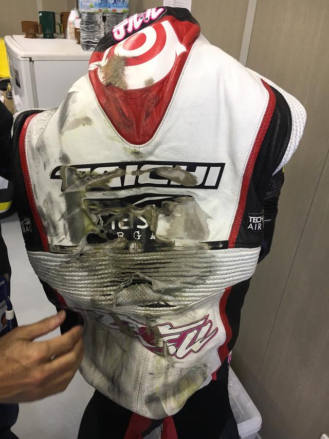 画像: こちらは前戦のアラゴンGPでクラッシュした、Teluru SAG Teamの長島哲太選手のレーシングスーツ。これだけ大きなダメージを受けると、即座のリペアは難しいですが、シャーリング部分や背中部分など、部分ごとのアッセンブリー修理が可能だそうです。