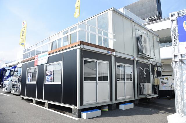 画像: チームカガヤマと同じ年、こちらはプレハブを建てこんだMotoMapサプライ。今年もスポンサーの三明電気工事さんが気合入れて建て込みと電気工事! 1階はヨシムラ、2階はサプライが使用し……↓