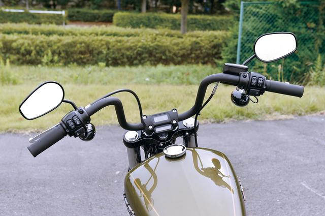 画像: ストリートボブといえば、拳を高く突き上げて乗ることになるミニエイプバーが欠かせない。グリップは肩の高さで、アップライトでリラックスしたライディングポジションとなる。