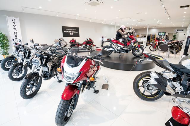 画像: 360°全方位から眺められるよう、展示車両の間隔がゆったり取られた店内。中央にある円形ステージがお店の外からも目を引くインパクトでした! こちらの“お立ち台”には下村店長のイチオシ注目モデルが展示されるのだとか。
