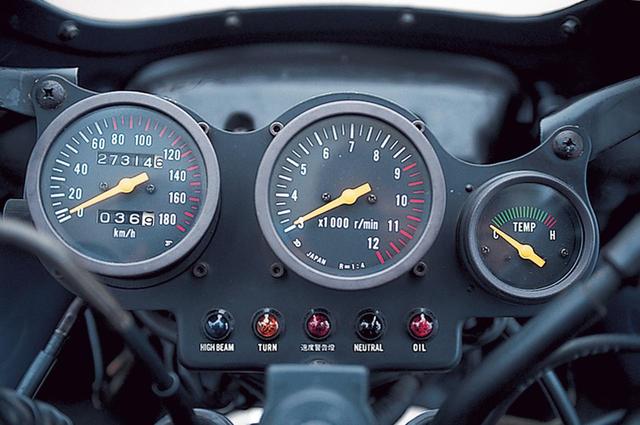画像: プレートに埋め込まれたメーターはレーサーを思わせるデザインで、12000rpmスケールで3000rpmを起点とするタコメーターを中央に配置する。左は80~180㎞/hの目盛りを赤としたスピードメーター、右は水温計だ。下側には各種インジケーターランプが並び、左から、ハイビーム、ウィンカー、速度警告灯、ニュートラル、オイルプレッシャーとなる。