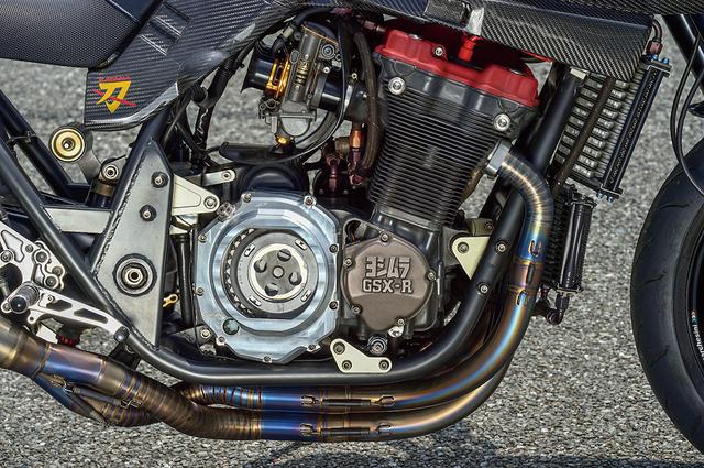 画像: エンジンは早い段階で'91GSX-R1100油冷に換装されていた。ポート加工とヨシムラST-1カム組み込みなどで150psを発揮、この換装でも軽量化が行われた。クラッチカバーはスケルトンタイプ。キャブはTMR-MJNブラックアブソリュート/デュアルスタックを装着する。