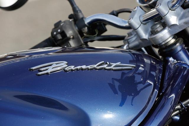 画像: 2代目バンディット250の初期型はタンクのロゴが「SUZUKI」のプリントだったが、後期型では「Bandit」表記の立体ロゴに変更されている。写真のスタンダードモデルにはないが、250Vではセパハンの逃げとなる窪みが設けられる。
