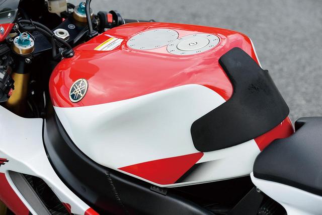 画像: 軽量なアルミ製燃料タンクは耐久レース出場を見据えて23Lという大容量。タンク上面にはクイックチャージャーの受け口用スペースまで確保されている。タンク幅は広めだが、ヒジでホールドしやすいというメリットもある。