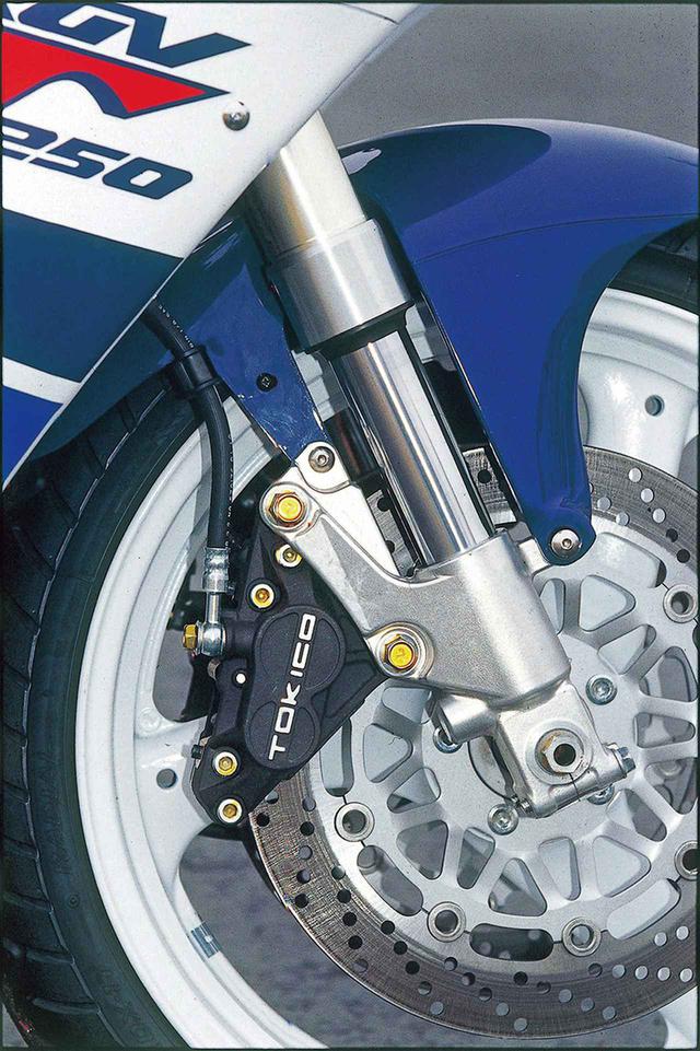 画像: 新採用となる倒立式フロントフォークはインナーチューブ径41㎜で、標準モデルはプリロードのみ、スポーツプロダクションの2モデルは全調整式。フローティングのブレーキディスクは外径が290→300㎜に拡大されるが、キャリパーはトキコの銘柄や、対向式異型4ピストン(φ34+30㎜)のスペックは不変。