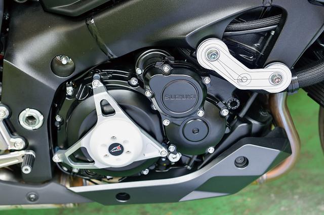 画像: クランクケースを保護するレーシングスライダーは同社の定番商品。アルミA2017削り出しのベースにポリアセタール製スライダーをスタイリッシュに組み合わせる。エンジン前側はマウントを連結する独自形状(写真では確認用型紙で、右端写真に製品が見える)。