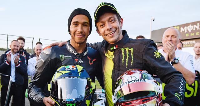画像: 互いのヘルメットを持って、肩を組むL.ハミルトン(左)とV.ロッシ。 www.yamahamotogp.com