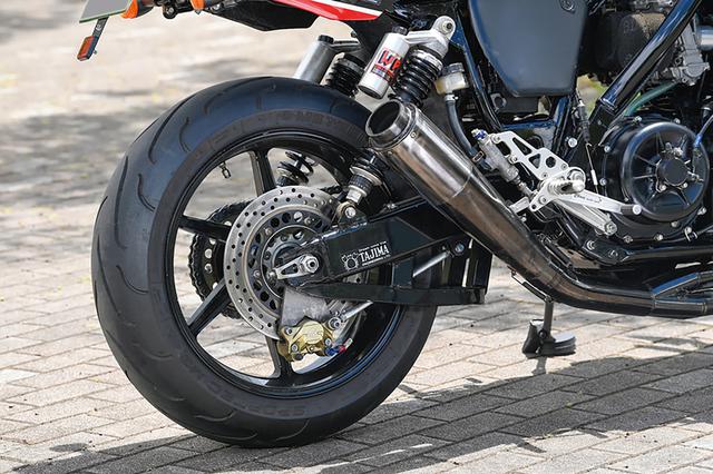 画像: スイングアームはホンダ系車両のものをタジマで加工。ホイールは3.50-17/6.00-17サイズの流用品だ。EXは同店オリジナルの4-1マフラーを装着する。