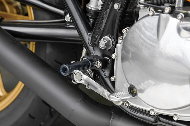 画像: ステップはノーマルよりもわずかにバー位置を後退させている。バー自体も車体コントロールをしやすいようにラバーを外し、新たにローレット加工された非可倒式バーに変更、ラバー同様のイメージを引き継ぐブラック仕上げでマウントしている。