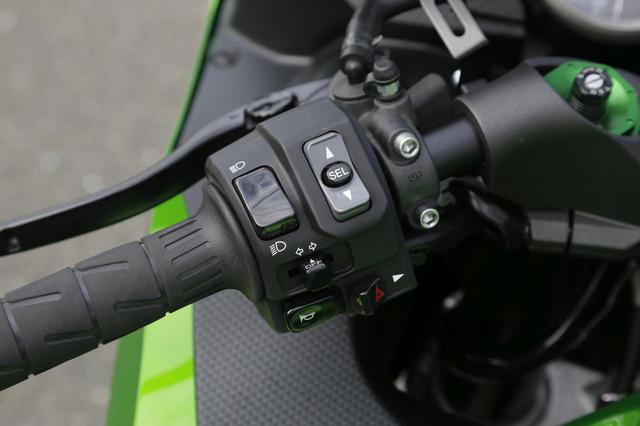 画像: 左ハンドルスイッチ。「SEL」ボタンでパワーモードとTRCモード、「SEL」ボタンなし上スイッチは液晶メイン表示切替、下スイッチでオド&ツイントリップ切替。ハイグレード仕様(=HG)はブレンボ製のラジアルマスターシリンダー+ローター+キャリパーを標準装備。ステンメッシュホース仕様で、ブレーキレバーは無段階に調節可能。