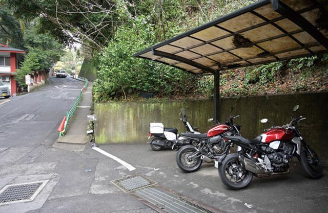 画像: 鳥居を正面に、右側の坂を入ると二輪用スペースが。バイクの出し入れに優しいフラットな場所で、屋根付きの配慮もありがたいですね。